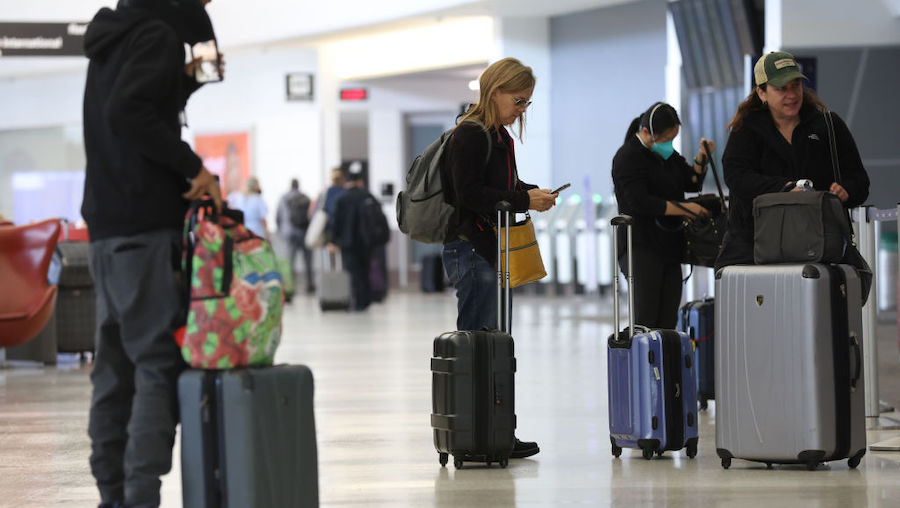 United Airlines customers prepare to check in for flights at San Francisco International Airport on...