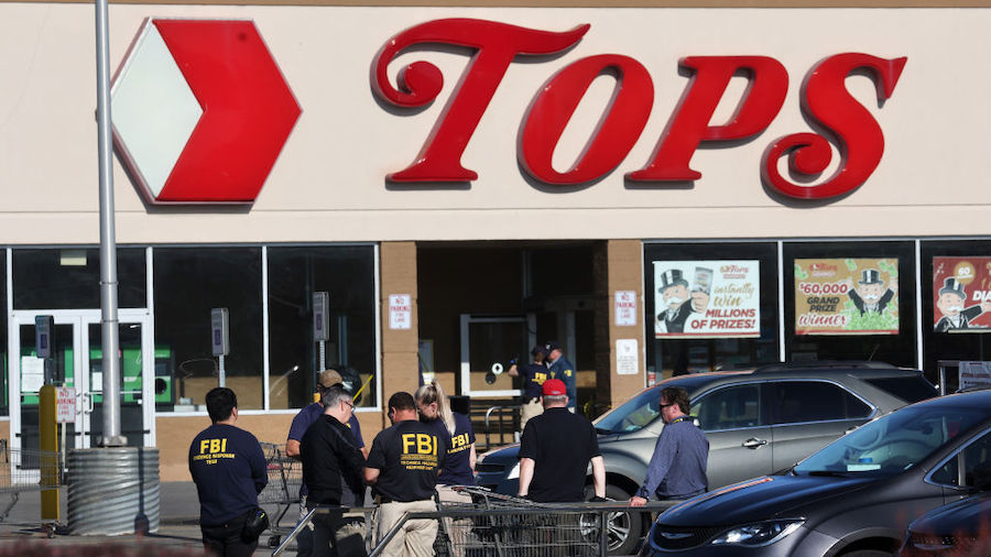 Police and FBI agents continue their investigation of the shooting at Tops market on May 15, 2022 i...