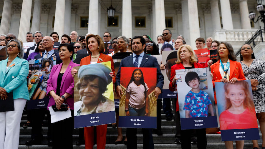 Speaker of the House Nancy Pelosi (D-CA) stands with fellow Democrats holding photographs of the vi...