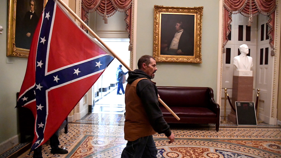 Kevin Seefried carries a Confederate battle flag on the second floor of the U.S. Capitol on January...