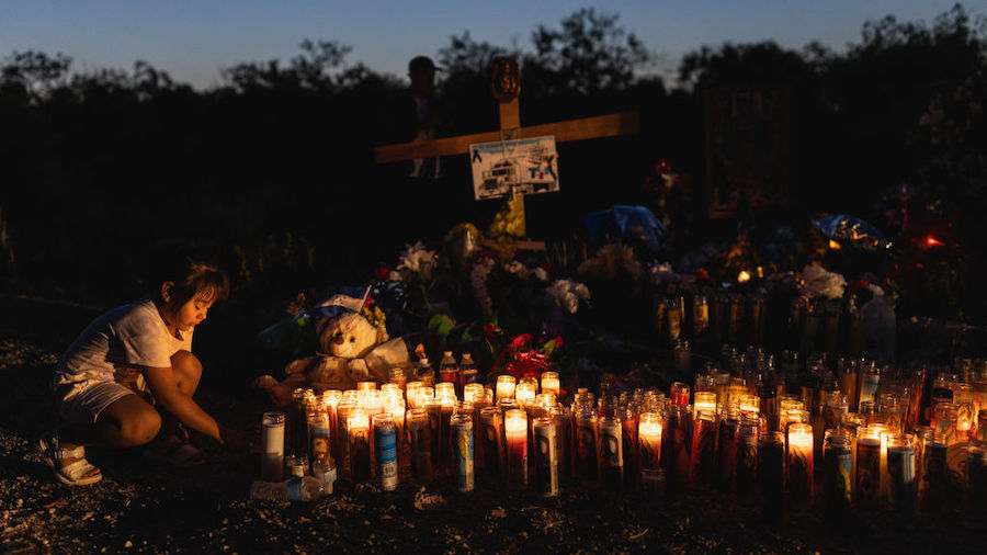 People gather at a makeshift memorial which has been erected at the site where 53 migrants died in ...