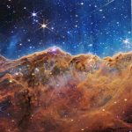 IN SPACE - JULY 12: In this NASA photo a landscape of mountains and valleys speckled with glittering stars is actually the edge of a nearby, young, star-forming region called NGC 3324 in the Carina Nebula. (Photo by NASA, ESA, CSA, and STScI via Getty Images)