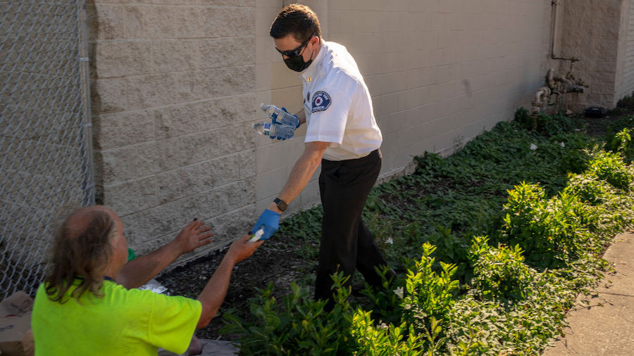 Gabe DeBay, Medical Services Officer with the Shoreline Fire Department, gives hand sanitizer and w...