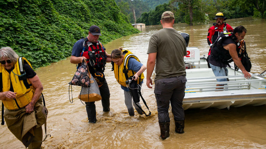 Members of a rescue team assist a family out of a boat on July 28, 2022 in Quicksand, Kentucky. Sto...
