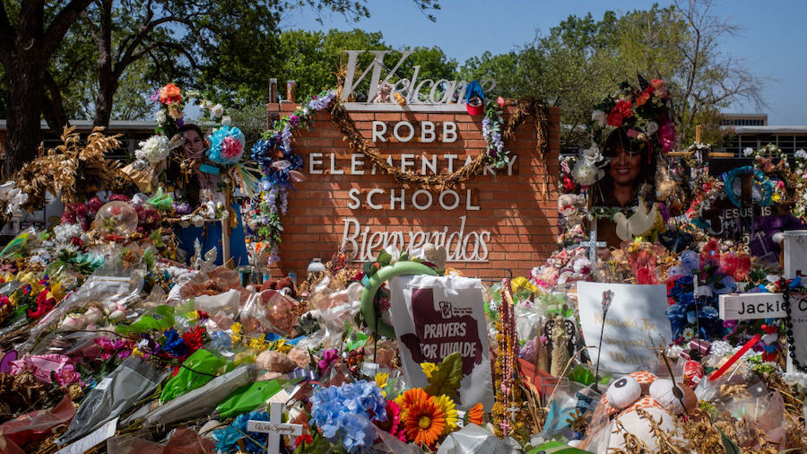 The Robb Elementary School sign is seen covered in flowers and gifts on June 17, 2022 in Uvalde, Te...