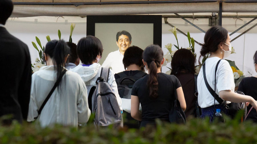 People lay flowers during a vigil for former Japanese Prime Minister Shinzo Abe at Zojoji temple on...