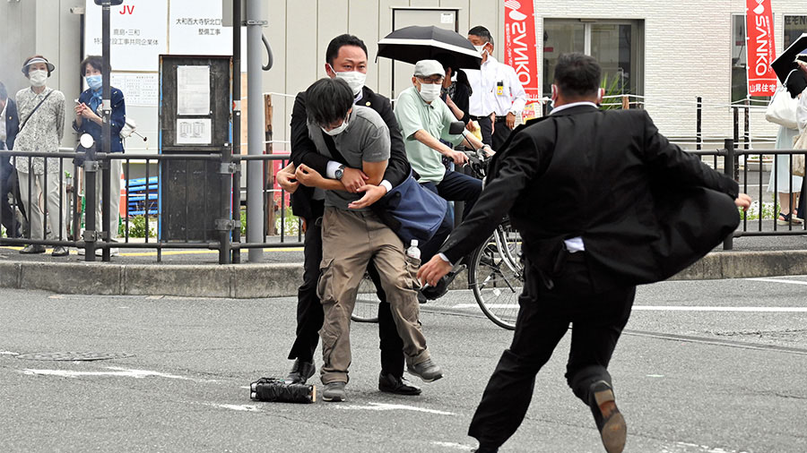 Security personnel detain Tetsuya Yamagami near the site where Shinzo Abe was shot in Nara, Japan, ...