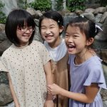 Sisters Sai, 11, Yue, 10, and Noe, 9,Tanaka laugh as they enter the Tokyo Japan Temple rededication in Tokyo on Sunday, July 3, 2022. (Credit: The Church of Jesus Christ of Latter-day Saints)