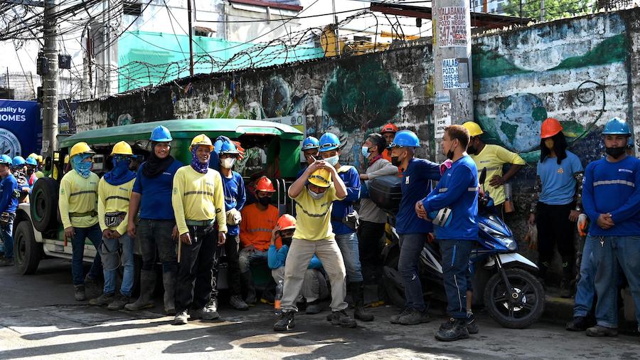 Construction workers evacuate a building after a 7.1-magnitude earthquake, some 400 kilometers away...