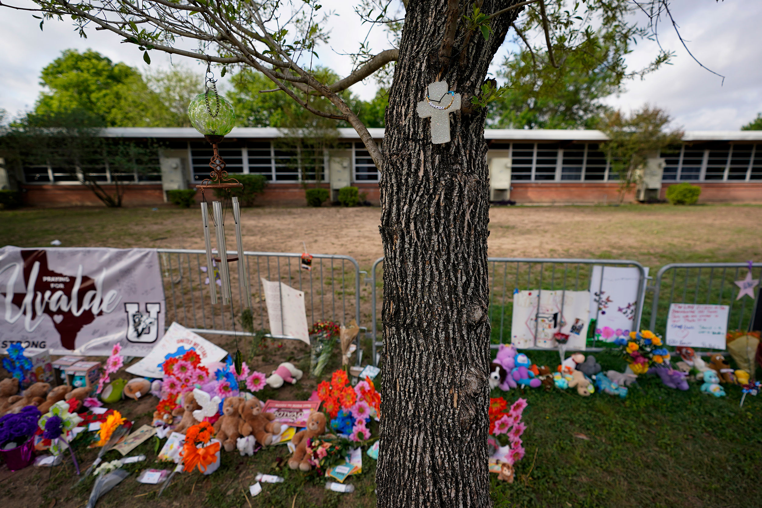 FILE - A cross hangs on a tree at Robb Elementary School on June 3, 2022, in Uvalde, Texas, where a...