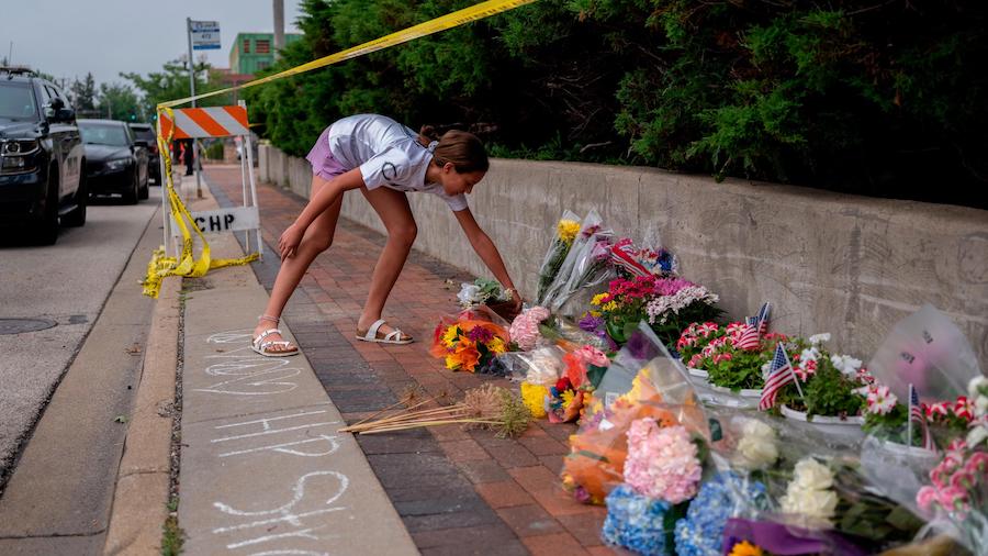 A mourner visits a memorial for the victims of a mass shooting at a Fourth of July parade, in Highl...