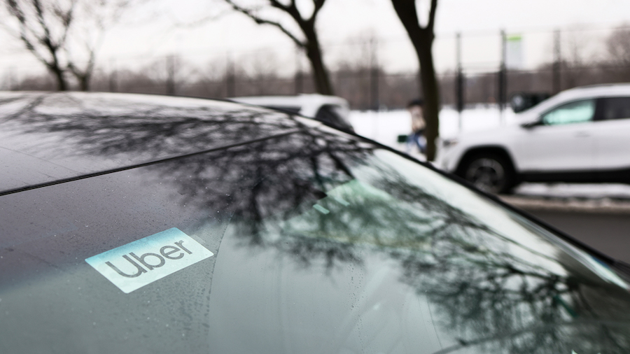 An Uber sticker is seen on a parked car in New York City in February 2021. Five more passengers are...