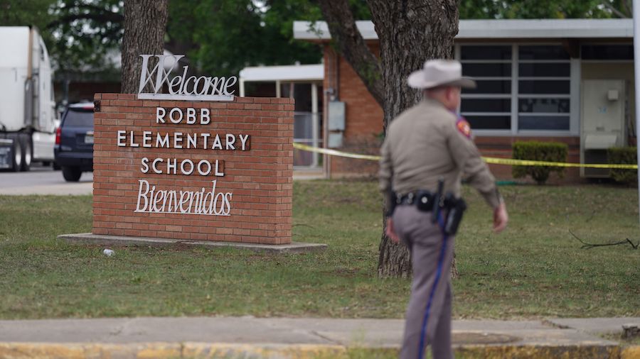 An officer walks outside of Robb Elementary School in Uvalde, Texas, on May 24. (Allison Dinner/AFP...
