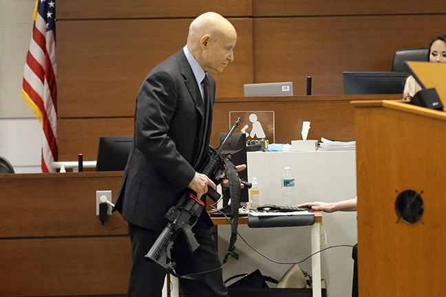 Assistant State Attorney Mike Satz handles the gun used by Marjory Stoneman Douglas High School sho...