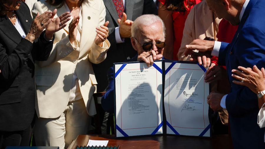 President Joe Biden holds up the bill after signing the CHIPS and Science Act of 2022 during a cere...