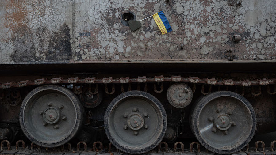 A Ukrainian national flag on a burnt-out Russian military vehicle displayed in the downtown area on...