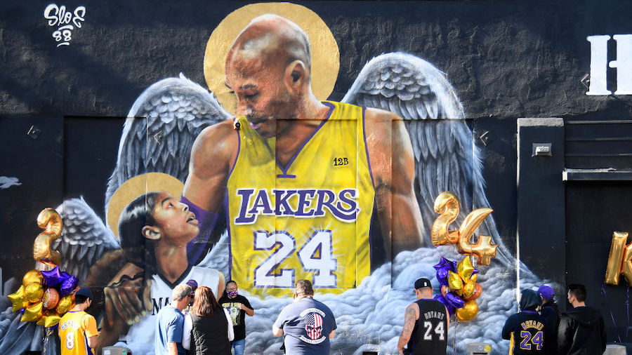 Fans stand in front of a mural painted in tribute to Kobe Bryant after his death one year ago on Ja...