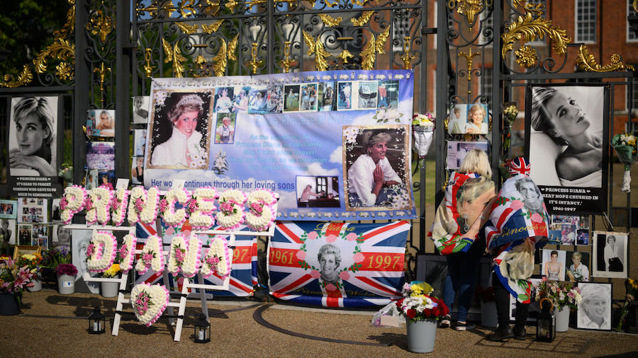 Messages and photographs of Princess Diana are seen on the gate as fans of the Royal Family gather ...