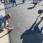 Teachers and parents writing welcoming messages for students.