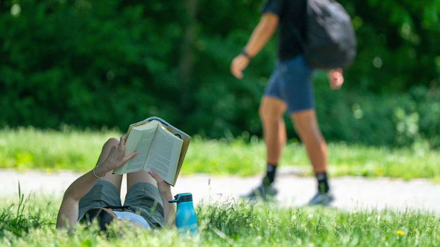 (FILE) - Person reading book outside....