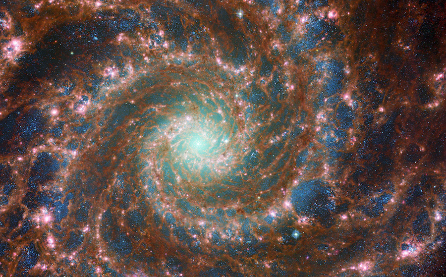 M74 shines at its brightest in this combined optical/mid-infrared image, featuring data from both t...