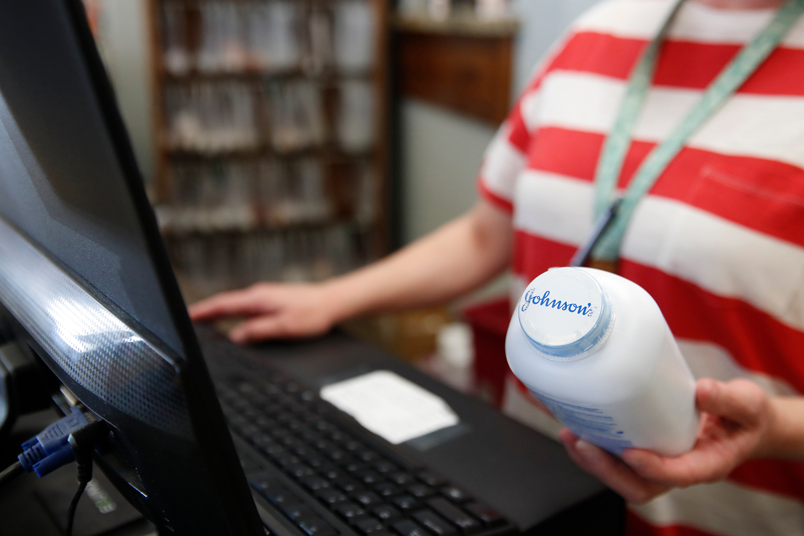 A cashier holds a bottle of Johnson & Johnson's brand baby powder at a pharmacy in Salt Lake Ci...