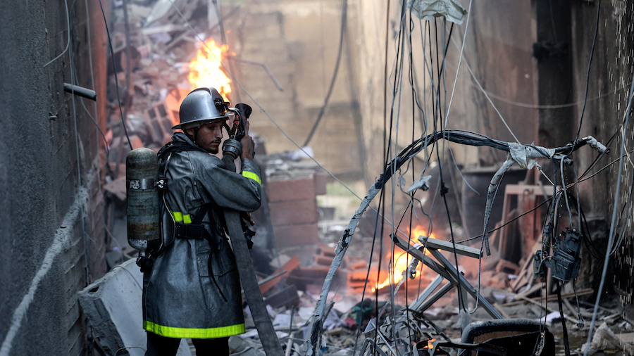 A Palestinian firefighter fights the blaze amid the destruction following an Israeli air strike on ...
