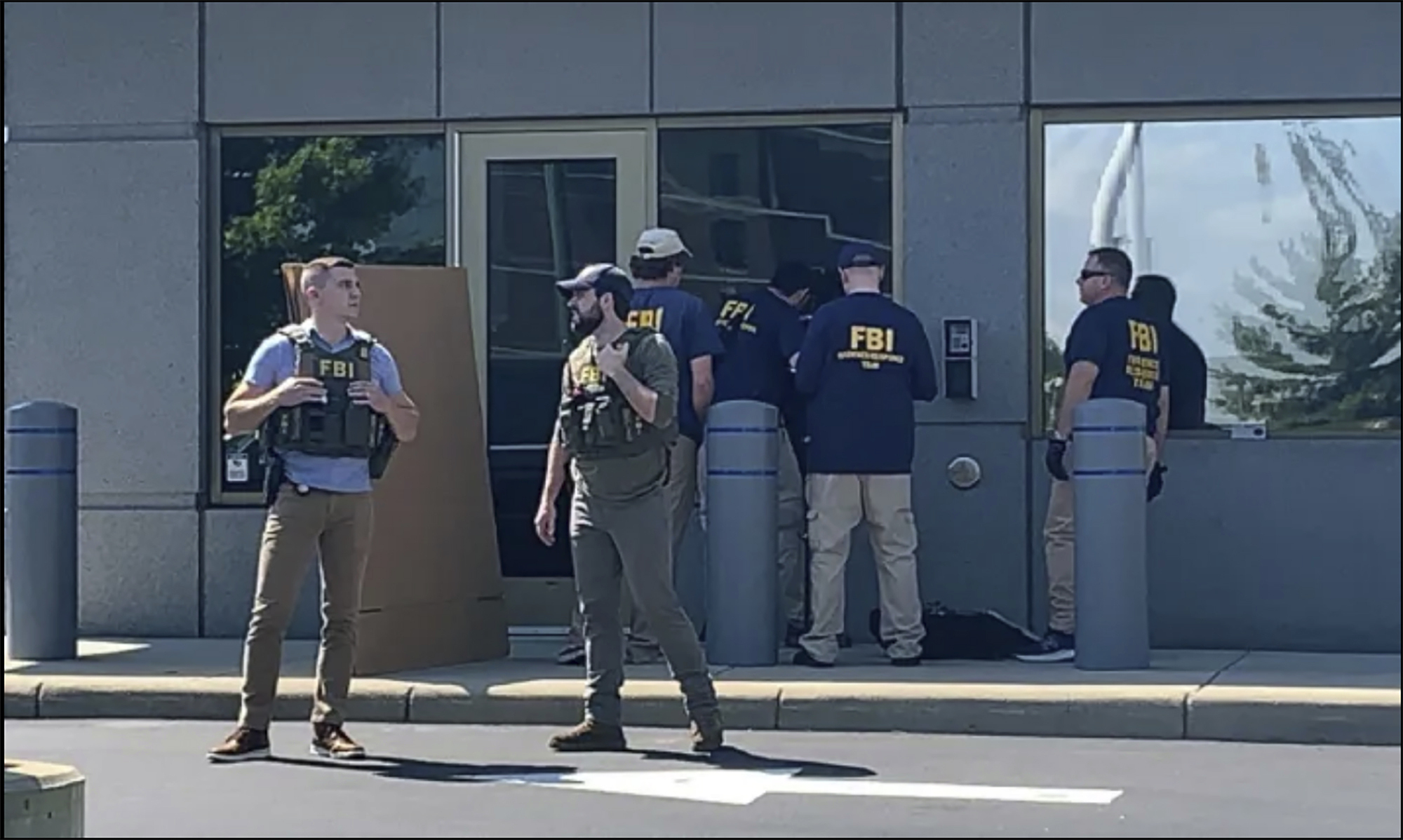 In this image taken from FOX19 Cincinnati video, FBI officials gather outside the FBI building in C...