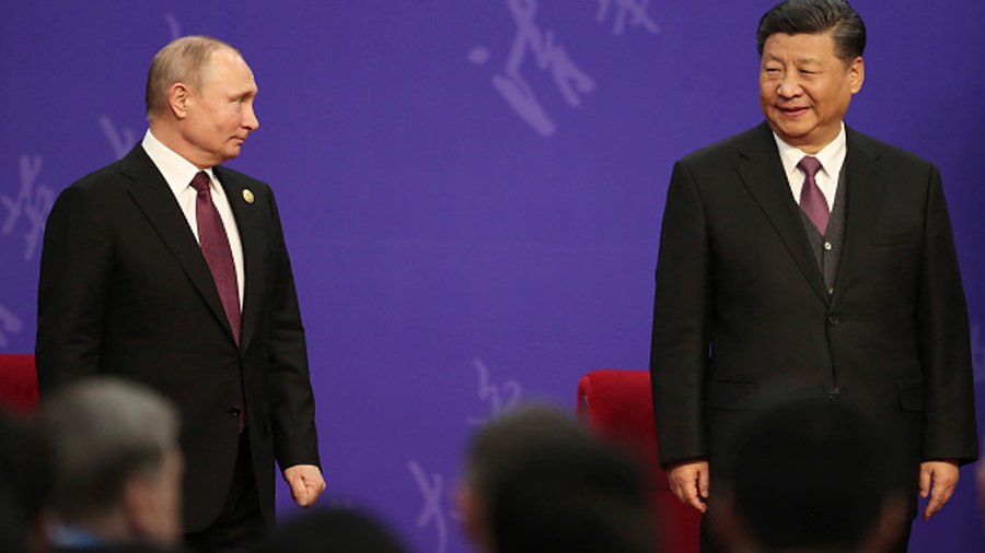 Russian President Vladimir Putin, left, and Chinese President Xi Jinping, right, attend the Tsinghu...