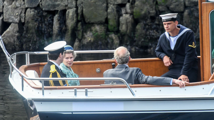 Imelda Staunton and other cast members are seen on a boat made to look like a Royal yacht tender in...