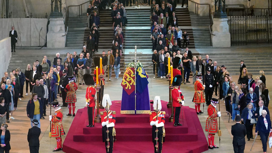 Members of the public file past the coffin of Queen Elizabeth II, draped in the Royal Standard with...