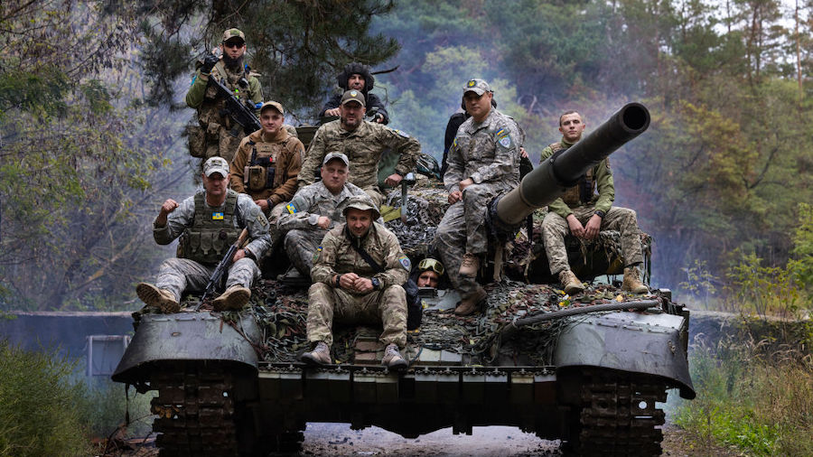 Ukrainian troops ride upon a repaired Russian tank in a wooded area outside the city on September 2...