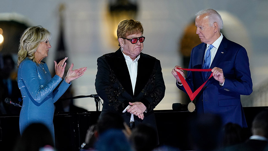 President Joe Biden presents Elton John with the National Humanities Medal after a concert on the S...