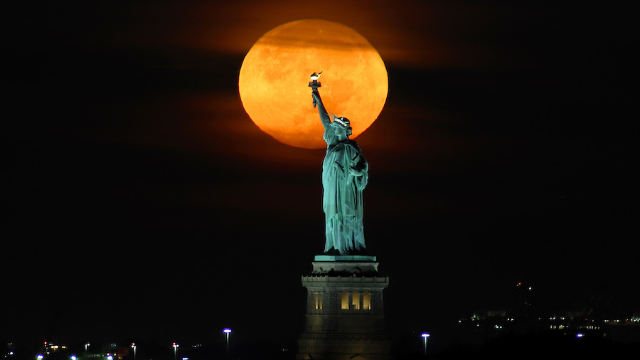 September's harvest moon will appear a deep orange color as it ascends into the sky. (Gary Hershorn...