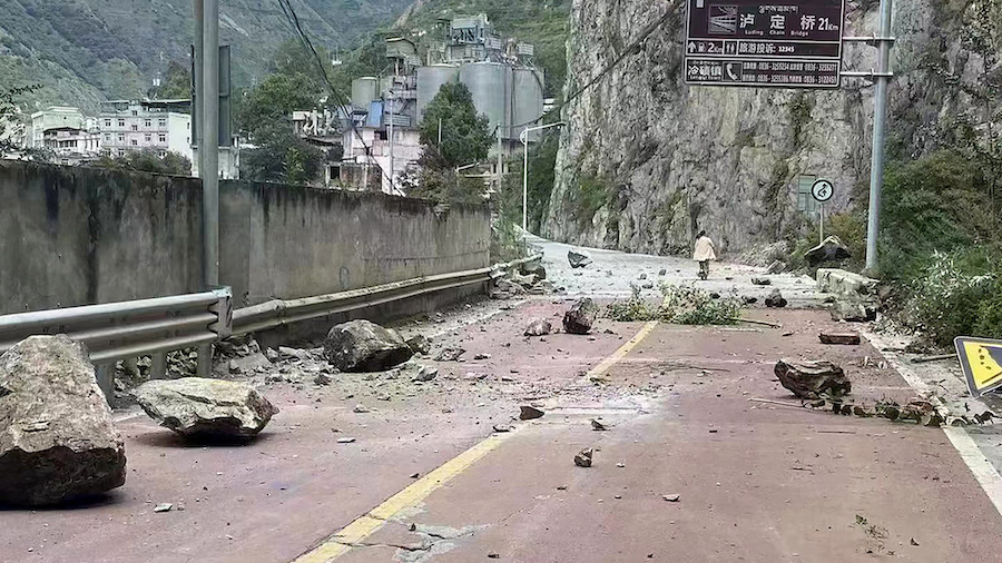 In this photo provided by China's Xinhua News Agency, fallen rocks are seen on a road near Lengqi T...