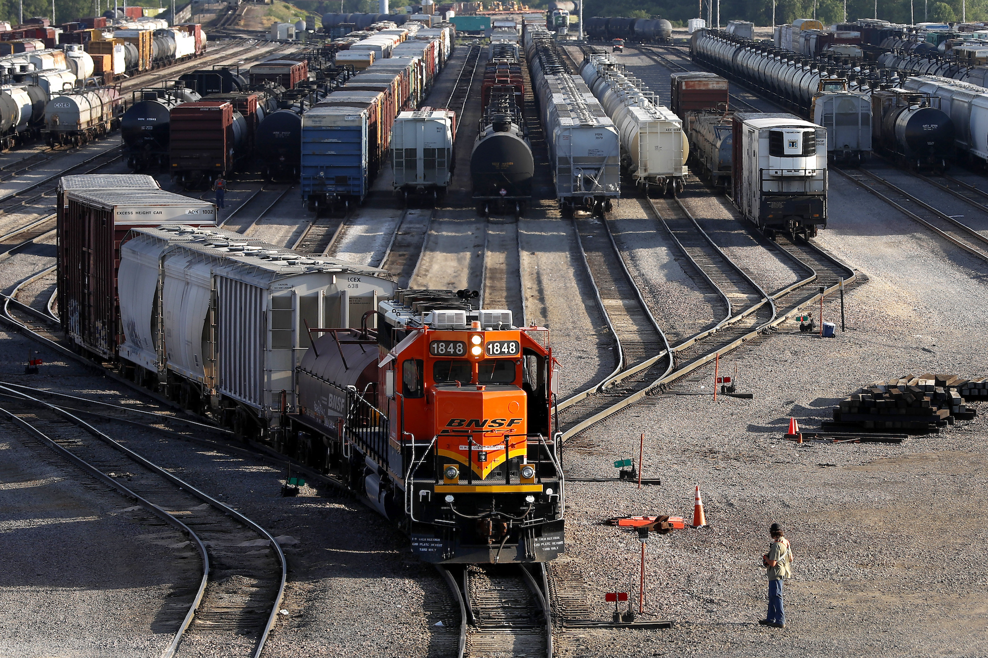 FILE- A BNSF rail terminal worker monitors the departure of a freight train, on June 15, 2021, in G...