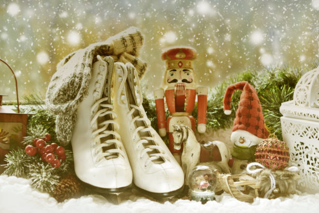 vintage toys and old skates with woolen socks on winter window sill as christmas gifts