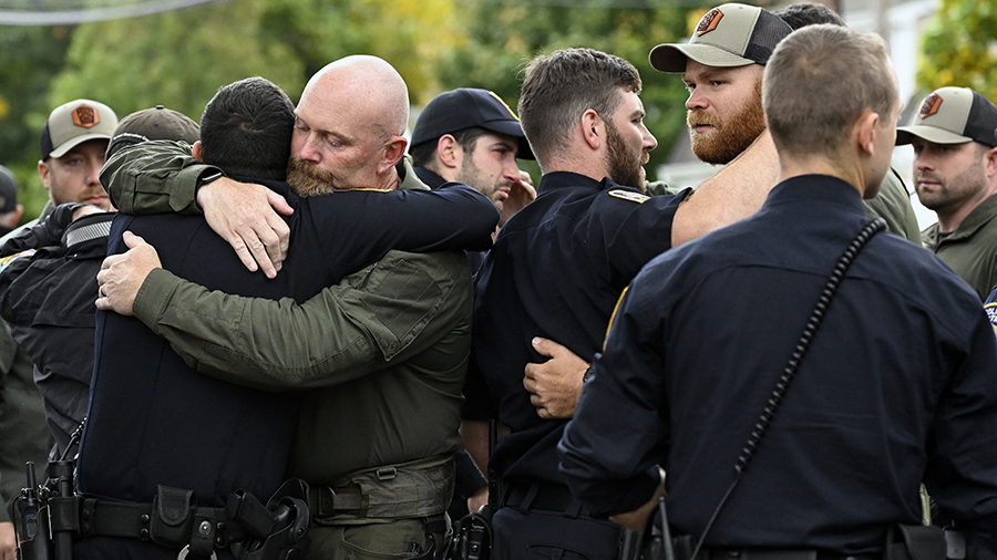 Bristol Police officers console one another at the scene where two police officers killed, Thursday...