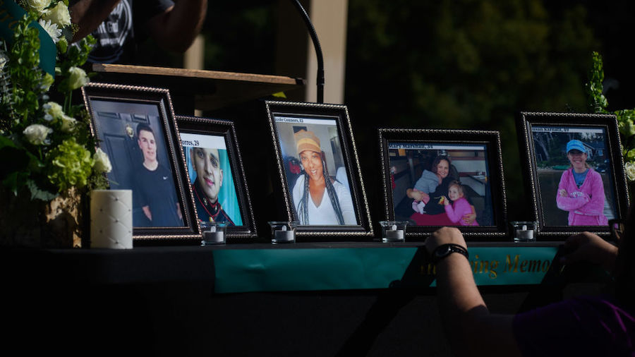 People set up a memorial table with images of the victims of a shooting in the Hedignham neighborho...