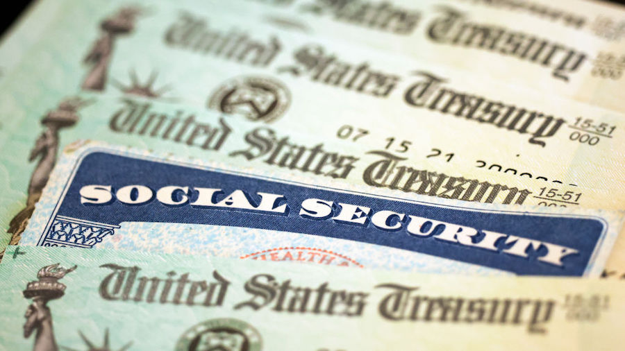 FILE: In this photo illustration, a Social Security card sits alongside checks from the U.S. Treasu...