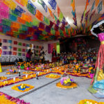 People pose for photos next to a traditional 'Dia de Muertos' offering set up by the municipality of Texcoco as part of the 2021 'Day of The Dead' celebration on November 01, 2021 in Texcoco, Mexico. (Alan Espinosa/Getty Images)