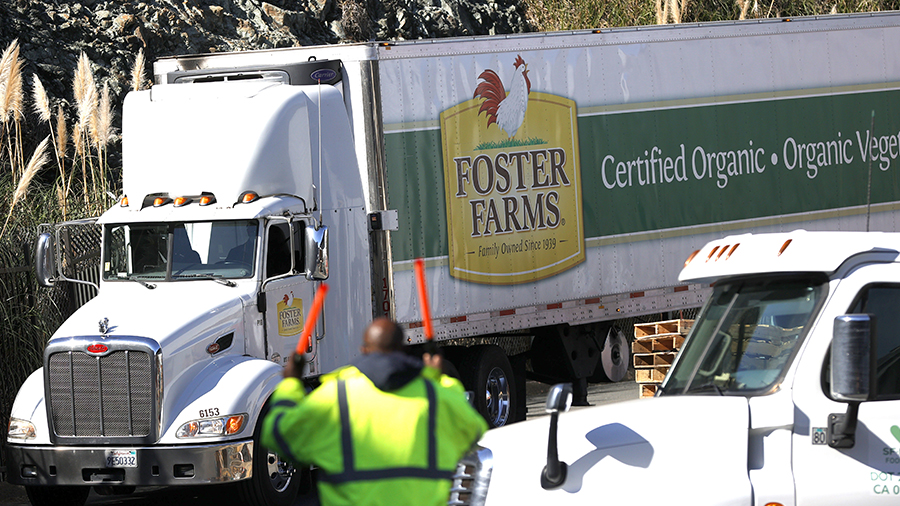 A worker guides a Foster Farms truck as it prepares to make a delivery at the SF-Marin Food Bank on...