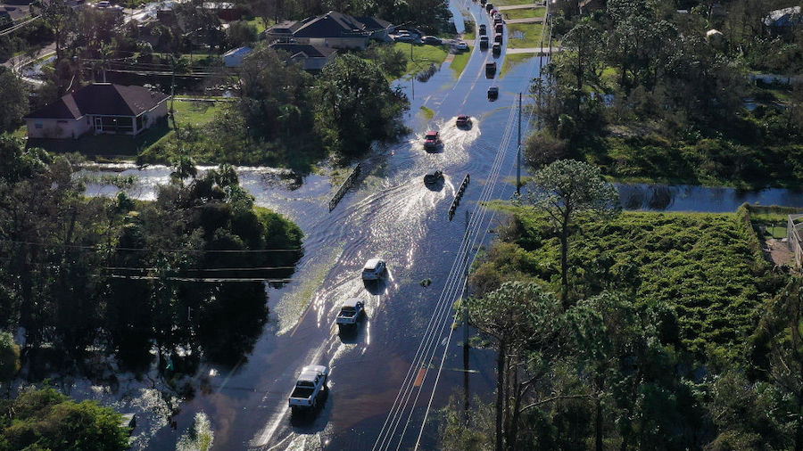 In this aerial view, vehicles drive through standing water left in the wake of Hurricane Ian on Sep...