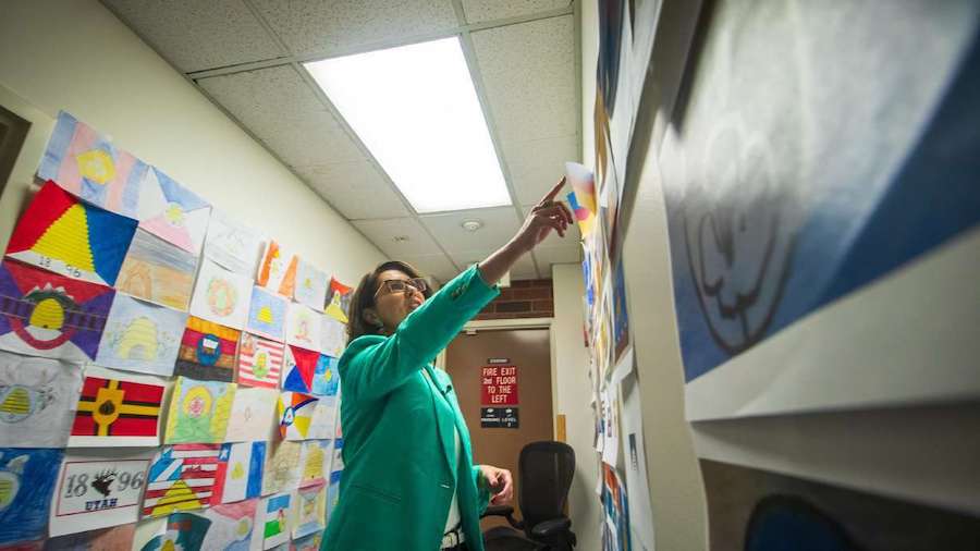 Lt. Gov. Deidre Henderson points to one of the 5,703 Utah state flag designs posted to the walls of...