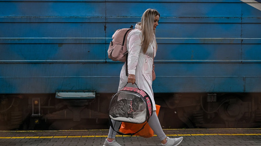 PRZEMYSL, POLAND - SEPTEMBER 30: A Ukrainian woman carries her cat in a bag as she gets off a train...
