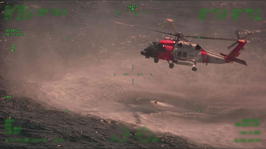A Coast Guard Air Station New Orleans MH-60 Jayhawk hovers over their rescue swimmer during a rescu...