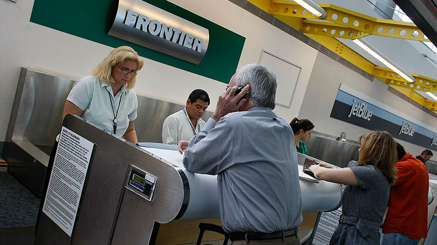 FORT LAUDERDALE, FL - APRIL 11:  Passengers check in at the ticket counter for Frontier Airlines Ap...