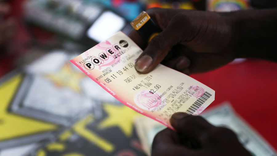George Hollins buys a Powerball ticket at the Shell Gateway store on March 26, 2019 in Boynton Beac...