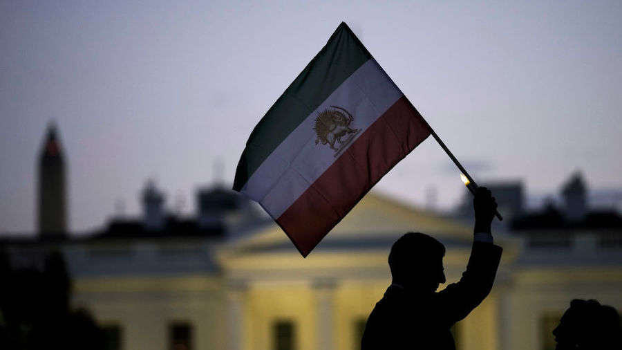 A man holds up an Iranian flag during a vigil in support of protestors in Iran and to mark 40 days ...