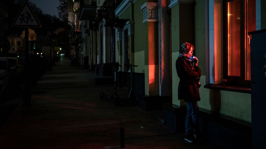 A woman stands outside a cafe on a dark street on November 07, 2022 in Kyiv, Ukraine. Recent Russia...